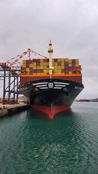 cargo de fret amarré au port de Port-Louis à l'île Maurice, conteneurs empilés à quai, lumière de fin de journée